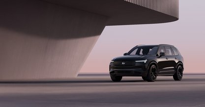 Volvo XC90 Black Edition паркиран на фона на бетонна стена
